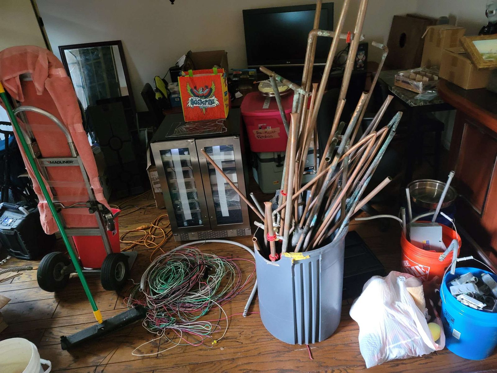 Before: cluttered indoor space with hand trucks, brooms, and wire coils ready for haul-out